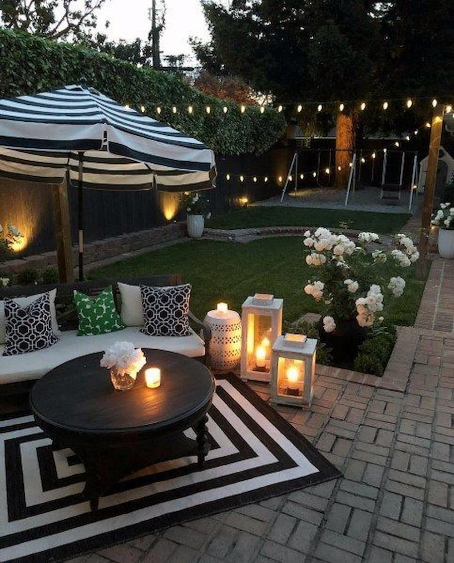 beautiful backyard with white sofa and black table with candles