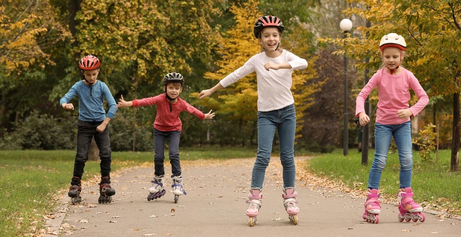 picture of four kids driving roller blades in a park